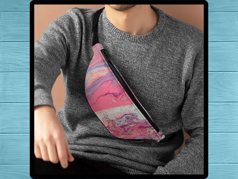 Male model wears the pink and purple street style bag across the chest, showing the hands-free pink fanny pack in action. A unisex adjustable pink belt bag that adds a bold pop of color and streetwear vibe, inspired by Greek summer fashion.