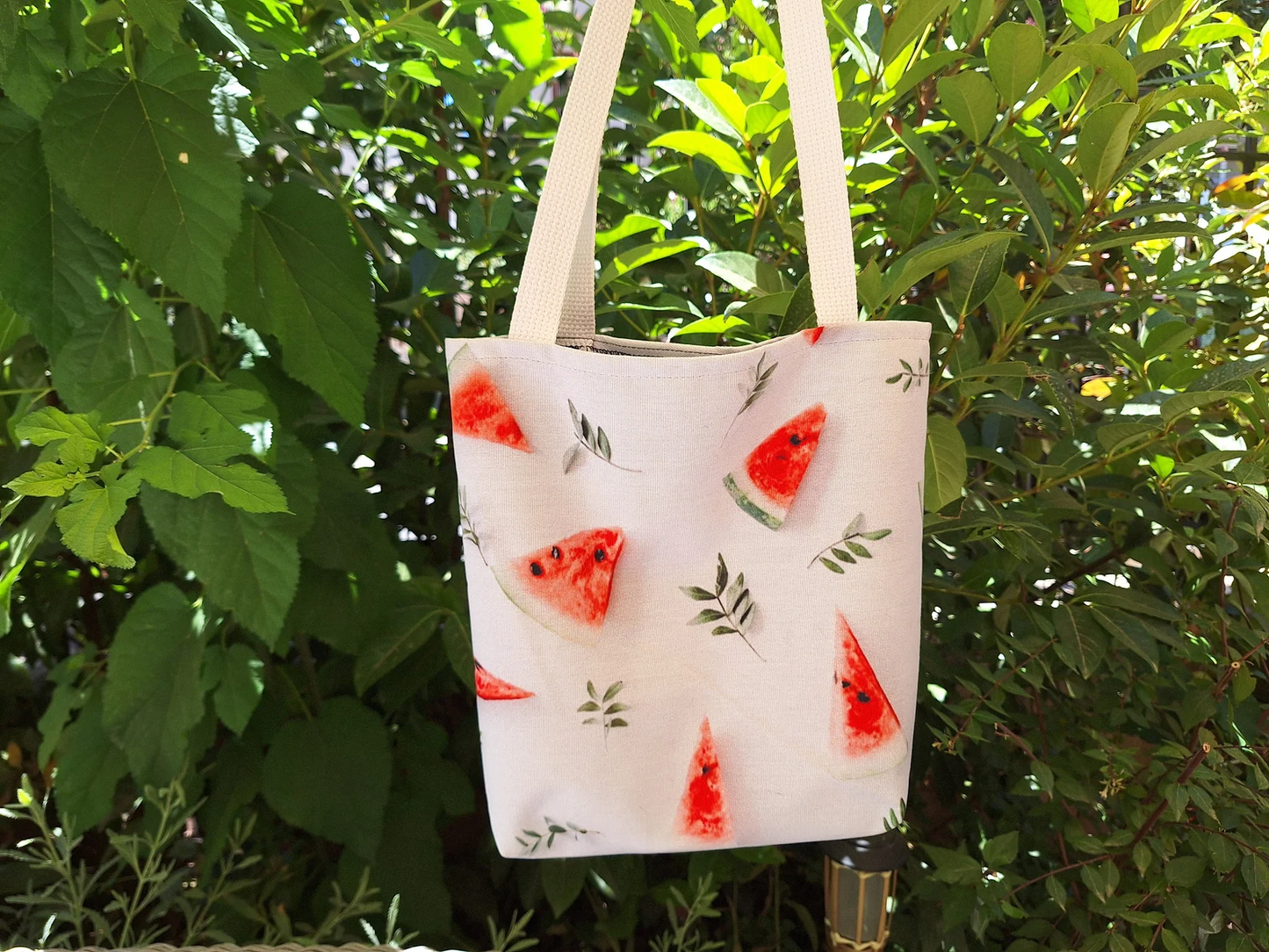 the Watermelon Bag, emphasizing the vibrant watermelon design and durable construction. This image provides a clear view of the bag's details, showcasing its quality as a stylish tote bag and a reusable shopping bag. The watermelon design makes it a perfect summer tote bag and a great gift for her. The sturdy straps and reinforced stitching are also highlighted, demonstrating its practicality as a beach tote bag.