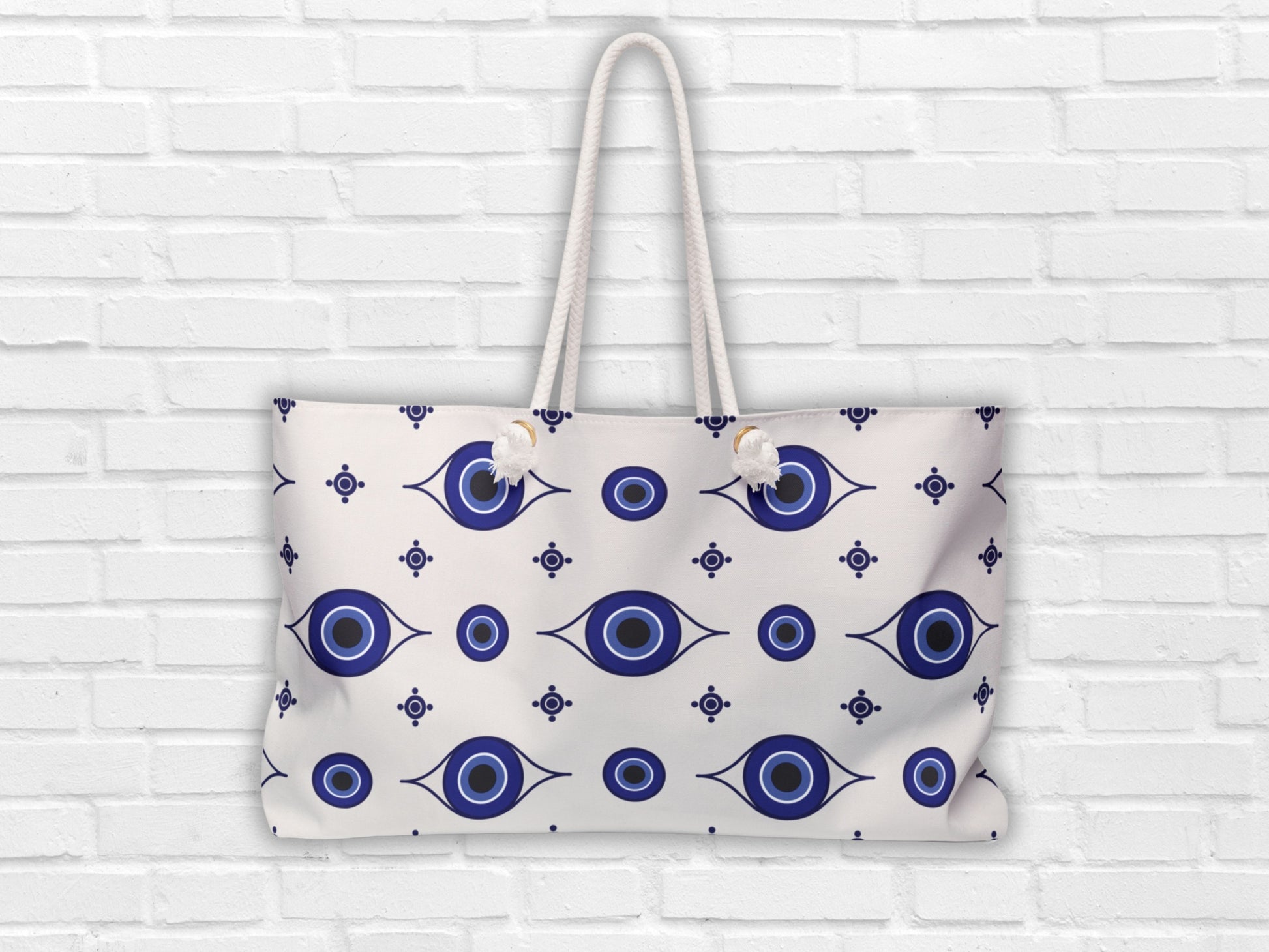 Evil eye bag on white background. Designed by Sea Sun Stories, this Greece inspired travel bag is perfect for vacation days. The Greek shoulder bag design and large capacity make it ideal as a summer bag or stylish Greek accessory.