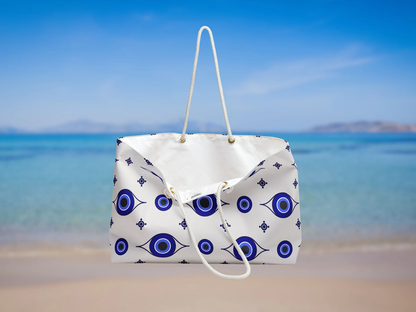 The open evil eye tote bag from Sea Sun Stories is shown filled with summer items. This Greek style beach tote is a must-have for travel to Greece. Featuring blue white bag tones and durable rope handles, it blends style with function. A great pick for Greece essentials or a Santorini bag.