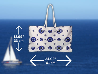 Detailed view of the Greece inspired travel bag with dimensions marked clearly. This blue and white Greek bag is perfect as a travel to Greece essential. With its roomy structure, rope handles, and evil eye design, this Greek shoulder bag fits beach towels, clothing, and sunscreen for every Santorini summer bag need.