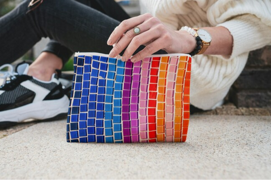 the Rainbow Clutch Bag, prominently displaying its Vibrant mosaic print bag design. This colorful bag, a faux leather clutch, is a true Statement clutch for any ensemble. It embodies the playful spirit of a rainbow clutch from Sea Sun Stories Clutch Bags, offering unique style.