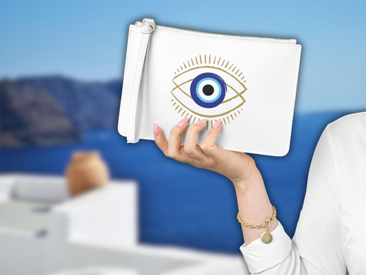 image featuring the White clutch bag with evil eye, prominently displaying its symbolic design. This white clutch, with its unique White evil eye motif clutch, presents a sleek and protective accessory. Its Slim white clutch profile makes it a stylish choice, embodying the charm of an evil eye bag from Sea Sun Stories Clutch Bags.