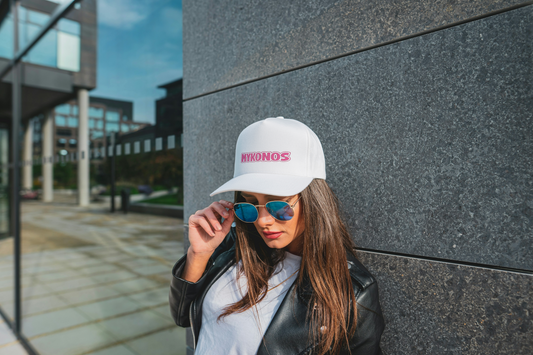 Woman wearing the Mykonos Hat styling it with resort wear. The Greece trip hat from Sea Sun Stories is great for Mykonos Beach Club hangouts or a casual mykonos bridal party vibe.