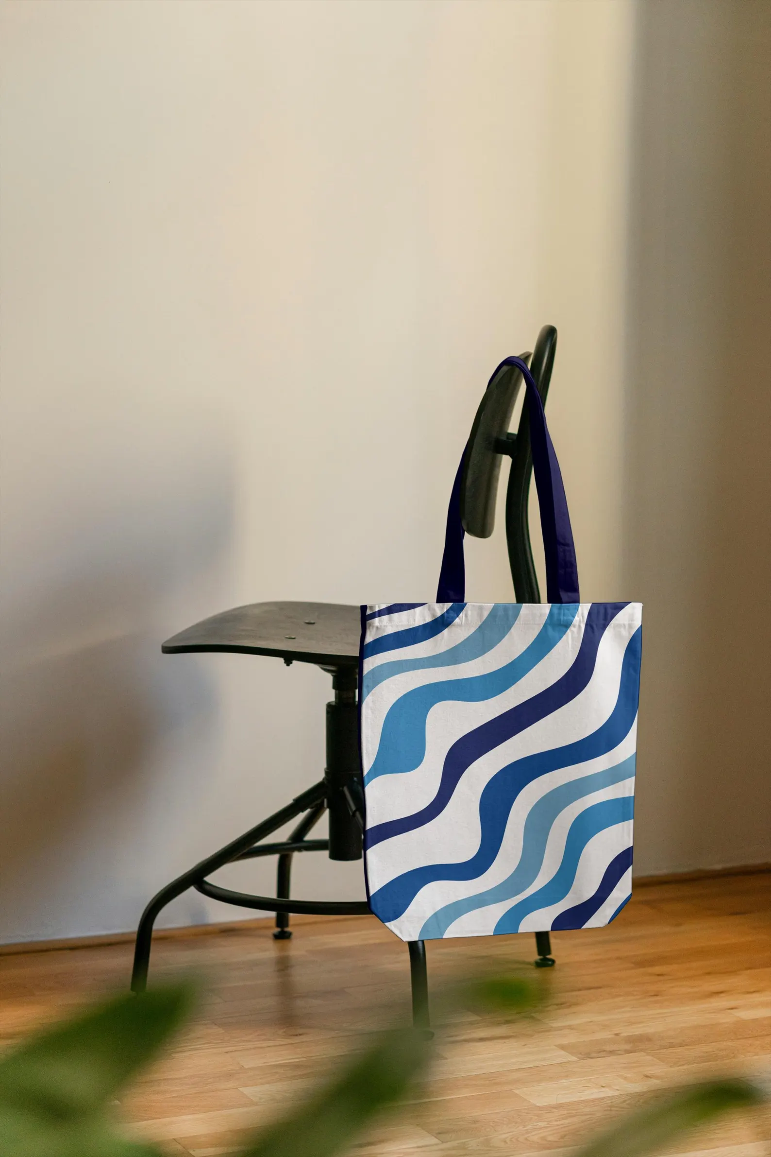The Blue striped Bag hanging on a chair, showcasing its design and shape. This image provides a clear view of how the bag looks when displayed, emphasizing its unique blue and white pattern and Greek island aesthetic. The image highlights the bag's sturdy construction and stylish appearance, making it a desirable accessory for any fashion-conscious individual.