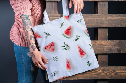 woman holding the medium watermelon bag, highlighting its capacity and fashionable watermelon design. This image emphasizes how this stylish tote bag can carry more items while still looking chic. The vibrant watermelon design makes it a standout summer tote bag. This fruit bag is perfect for everyday use.