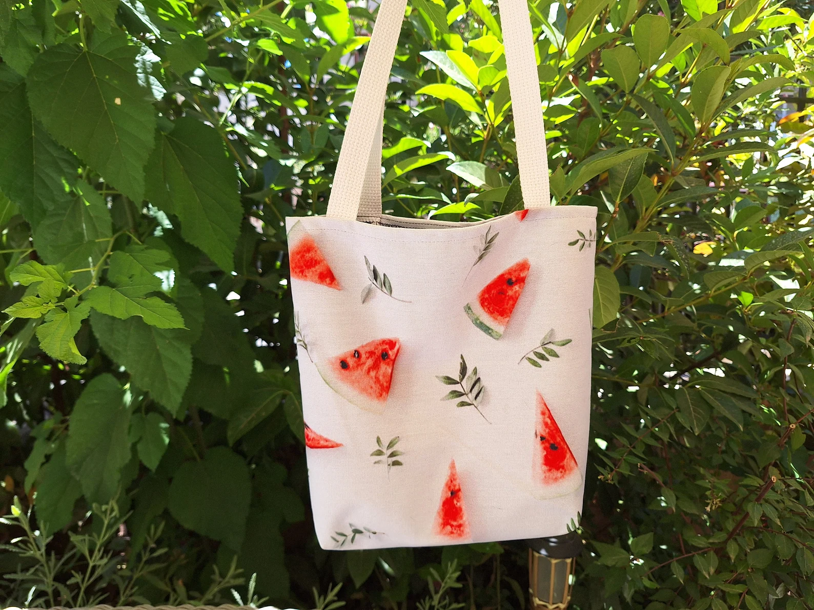 the Watermelon Bag, emphasizing the vibrant watermelon design and durable construction. This image provides a clear view of the bag's details, showcasing its quality as a stylish tote bag and a reusable shopping bag. The watermelon design makes it a perfect summer tote bag and a great gift for her. The sturdy straps and reinforced stitching are also highlighted, demonstrating its practicality as a beach tote bag.