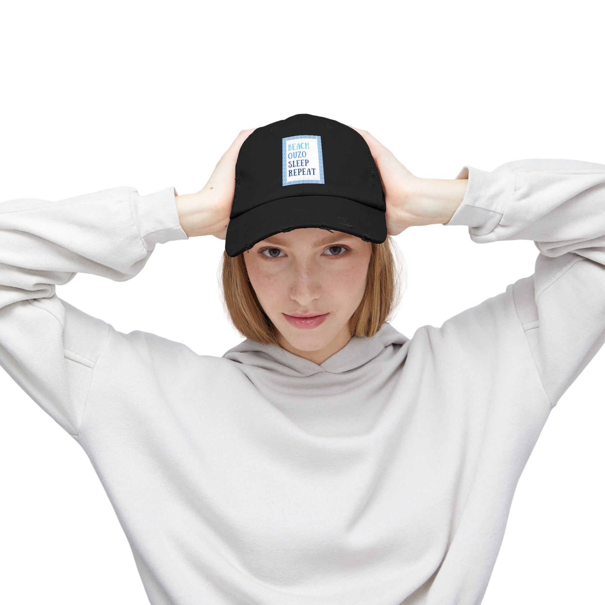 A woman stylishly wearing the black Ouzo hat on a sunny day. This Greek hat is a perfect accessory for any vacation.